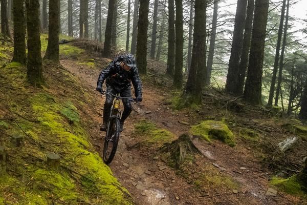 Elite DH racer Finn Iles wearing MTB trousers during a wet Fort William World Cup